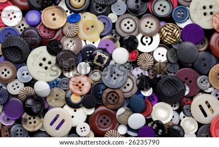 Background surface filled with a variety of dress-maker and clothing buttons, many of them vintage.