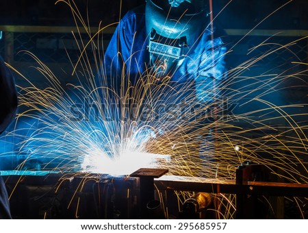 worker with protective mask welding metal