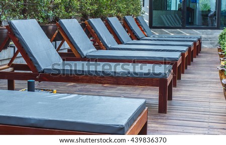 Pool Beds wooden horse long seats near the pool, wooden pool beds - closeup Pool Beds wooden horse long seats near the pool, wooden pool beds - closeup