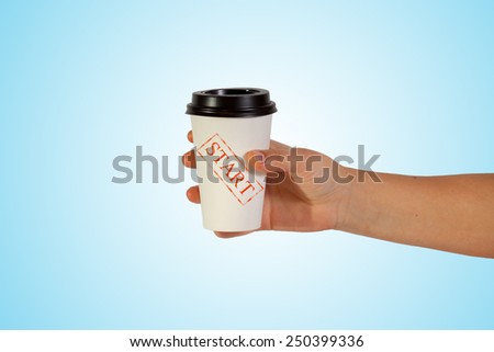 cup of coffee in hand on blue background with written start