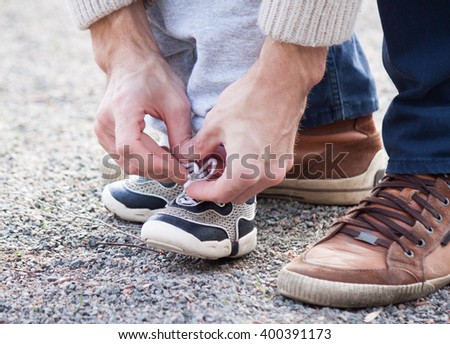 Dad tying the laces on a child sneakers