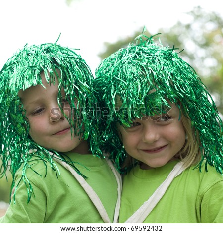Image of two cute toddlers in green costumes with funny green wigs