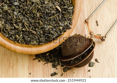 green tea, dried leaves with filter, on wooden background