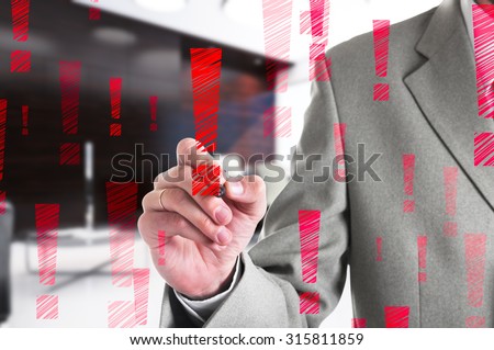 Businessman drawing a red exclamation mark. Business concept.