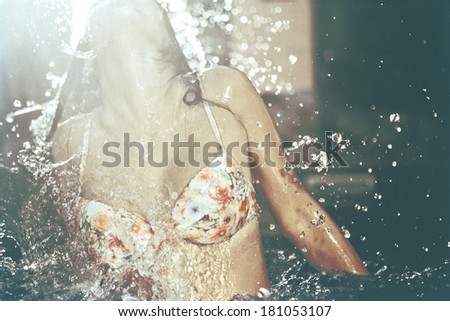 Girl splashing water out of a pool