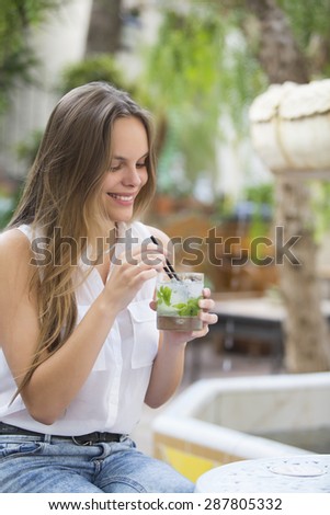 Girl drinking a cocktail in the garden