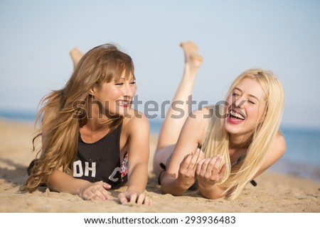 Two friends smiling at the beach