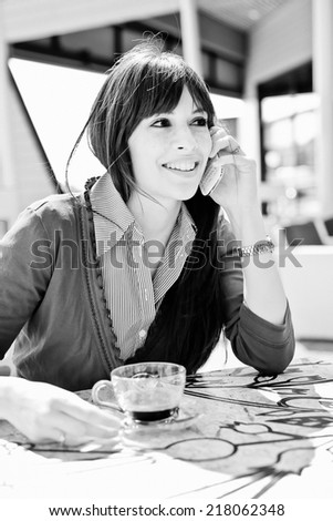 Young woman using a mobile phone in a Pub.