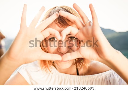 Woman and heart shaped fingers