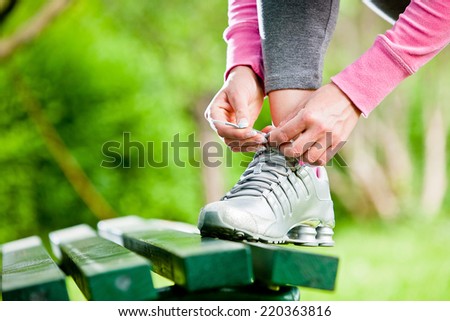 Female runner tying her shoelace outdoor