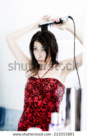 Natural Beauty straightening her long Hair. Woman doing morning routine in bathroom.
