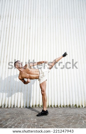 The muscular and young man in a high karate kick.