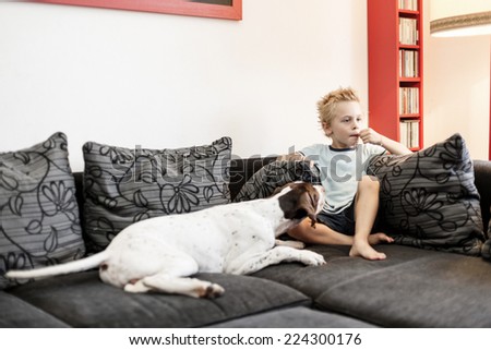 Young boy watching TV with his Dog