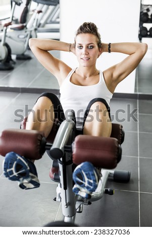 Fit young lady doing crunches in Health Club.