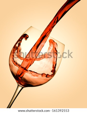 Red wine flows in a glass on a white background. Wine glass. Red wine in a glass.
