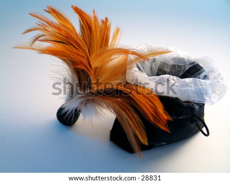 A feather brush leaning up against a bag of body powder