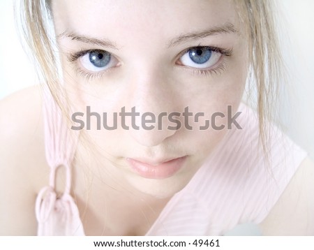 Woman staring into the camera, high key, pale pink tones, blue eyes. Crisp focus on the eyes.