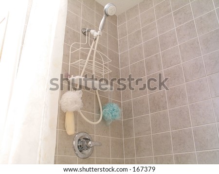 In the bathroom, shower with ceramic tile.