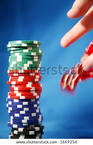 A stack of poker playing chips and a rolling die