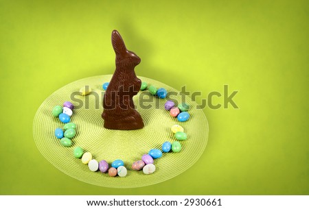Chocolate easter bunny standing amongst some easter eggs