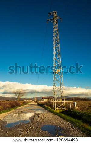 an electric structure next to a country road after the rain