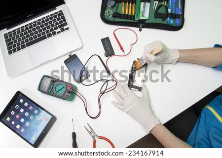 Prague, Czech Republic - NOVEMBER 30, 2014: Photo of the repair process of an iPhone 4. IPhone 4 are produced by Apple Computer, Inc..
