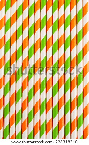 Halloween background of striped drinking straws in orange and green colors