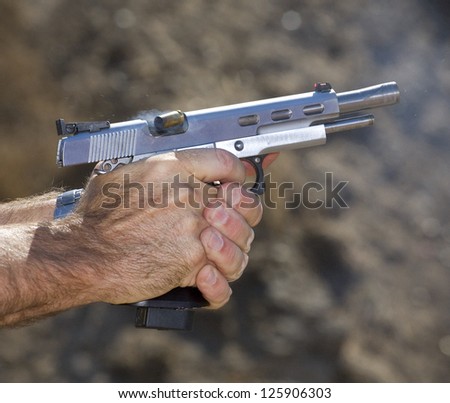 Empty brass shell being ejected from a semi automatic pistol