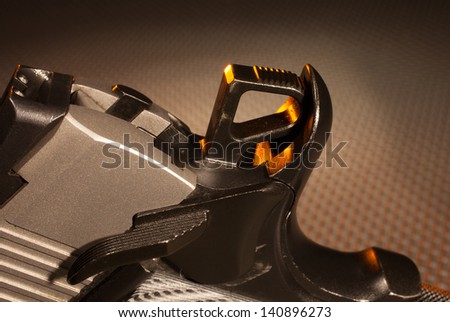 Hammer at the back of a semi automatic handgun with orange highlights