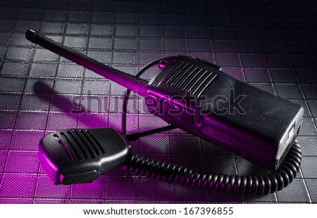 Radio and its microphone on a textured background with purple light