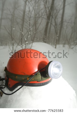 a climbing hard hat and a headlamp in snow