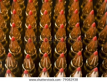 rows of red tipped copper plated bullets that are shining