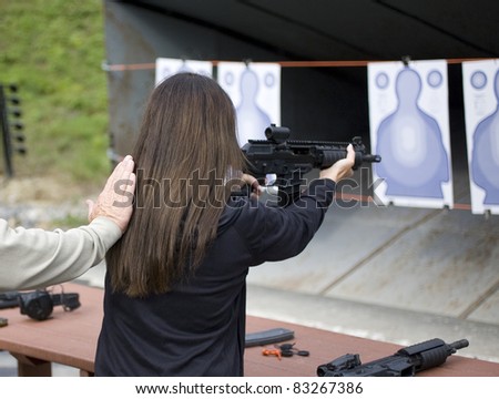 Woman who is shooting a fully automatic rifle at targets