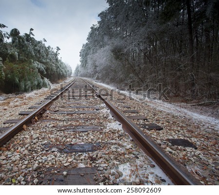 In the middle of the railroad tracks with the forest covered in ice