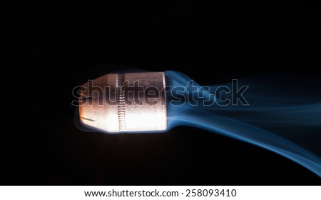 Hollow point handgun bullet with smoke trailing behind