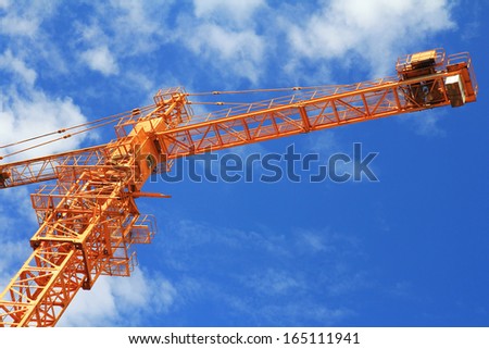 crane and blue sky on building site ,Crane and workers at construction site against blue sky