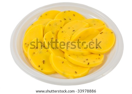 House caraway seed cheese on a plate sliced on a white background
