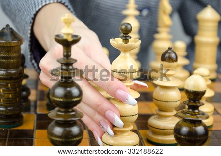Hand plays chess with beautiful nails