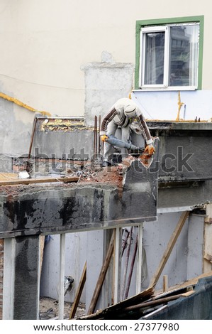 Construction worker at demolition of old building with jackhammer and working without hardhat