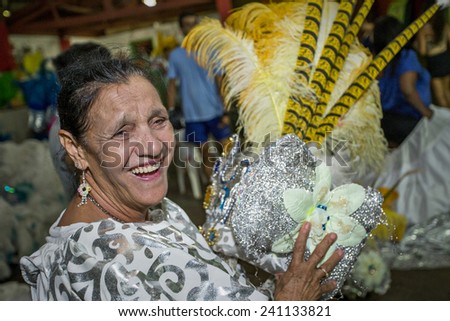 Old woman, putting feather hat for Carnival Parade. Preparation for Carnival Parade. 1 March 2014 Bonfim Paulista Ribeirao Preto Sao Paulo Brazil