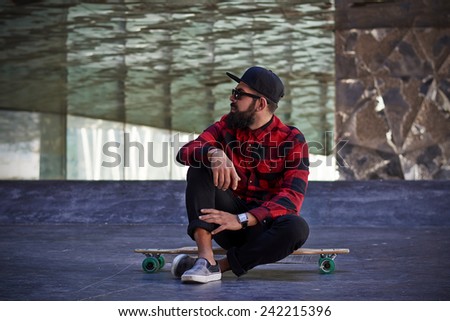 Young hipster man with a skateboard