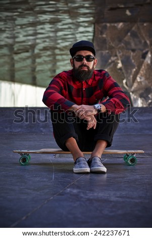 Young hipster man with a skateboard