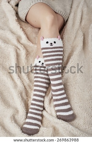 Woman on bed with bear socks