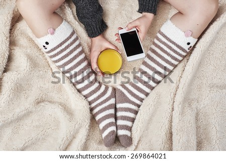 Woman on bed with bear socks and orange juice