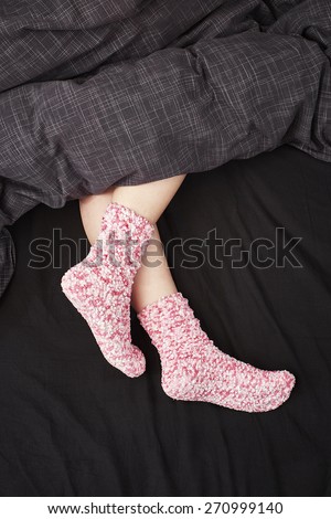 Woman with pink woollen socks in Bed