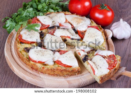 Slice of zucchini pizza and cheese on a wooden board