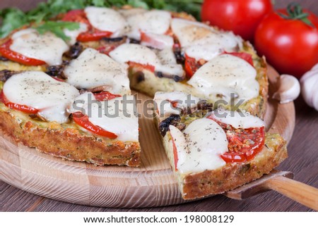 Slice of zucchini pizza and cheese on a wooden board, close-up