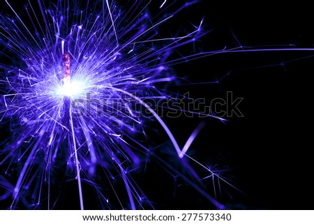Bright blue sparks from a sparkler