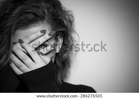 Black & White portrait of a young women hiding her face with her hands