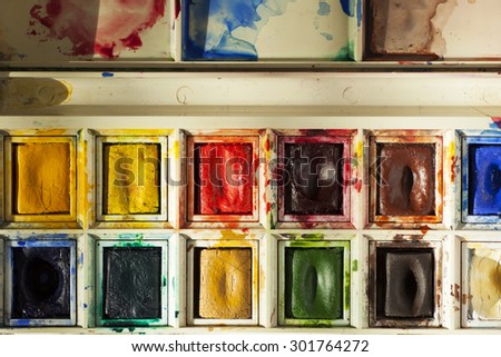 Used watercolour paint palette showing bright, well used paints